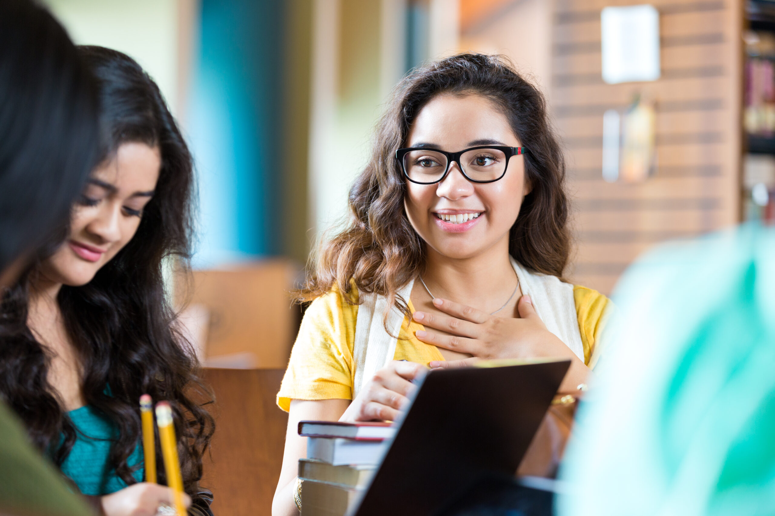 Hispanic college student studying with group of friends in library